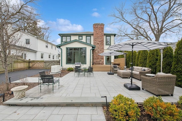 rear view of house with a patio area, entry steps, a chimney, an outdoor hangout area, and fence private yard