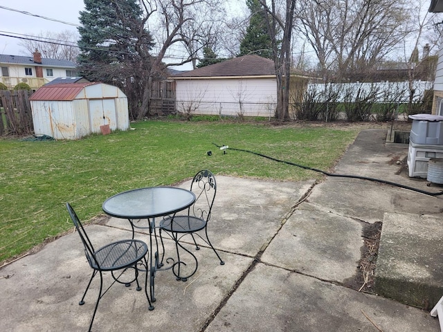 view of patio / terrace featuring an outbuilding, a storage unit, and a fenced backyard