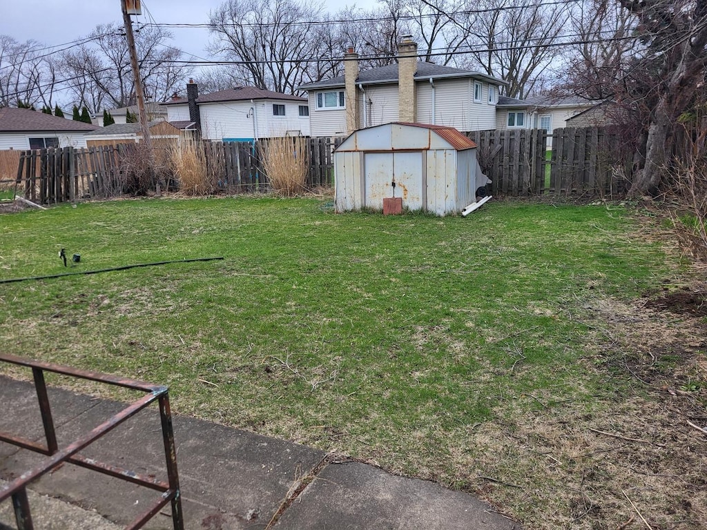 view of yard with a fenced backyard, a storage shed, and an outdoor structure