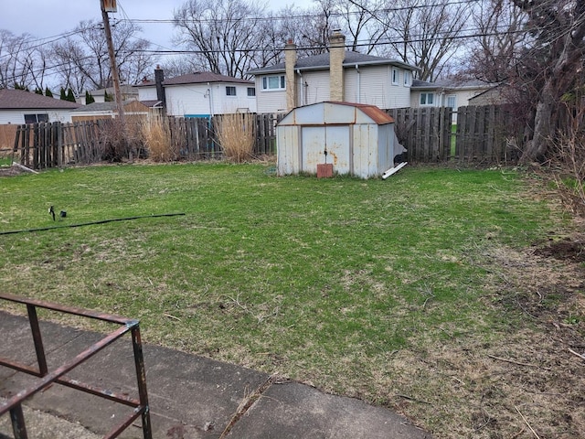 view of yard with a fenced backyard, a storage shed, and an outdoor structure