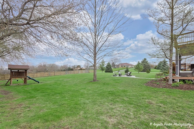 view of yard with a playground and fence