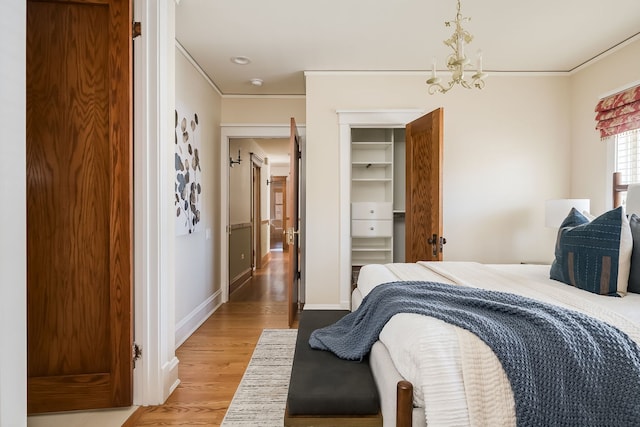 620 S Scoville Ave, Oak Park, IL 60304 - bedroom with a closet, a chandelier, light wood-type flooring, baseboards, and ornamental molding