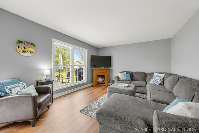 2690 Moss Ln, Aurora, IL 60504 - living area with wood finished floors, a lit fireplace, and baseboards