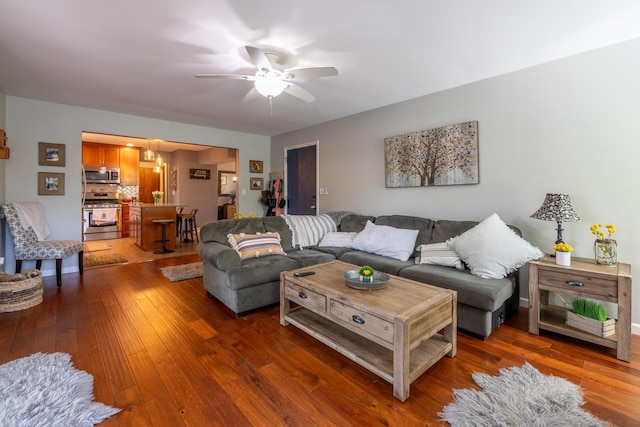 living area with ceiling fan, hardwood / wood-style flooring, and a chandelier