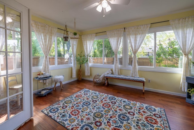 sunroom with plenty of natural light, hardwood / wood-style floors, baseboards, and ornamental molding