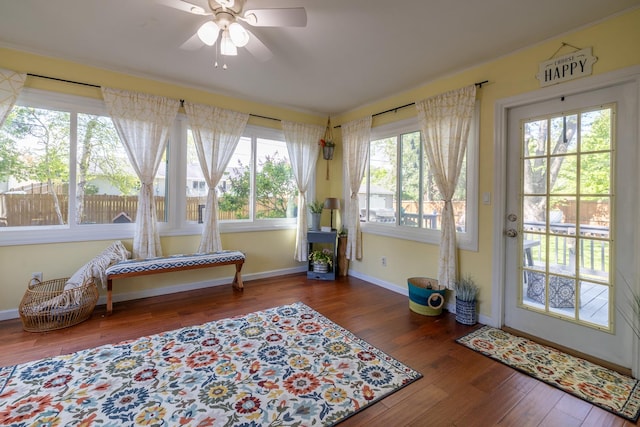 sunroom with baseboards, wood finished floors, and crown molding