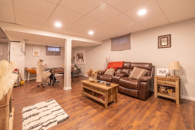 living room featuring wood finished floors, baseboards, and a drop ceiling
