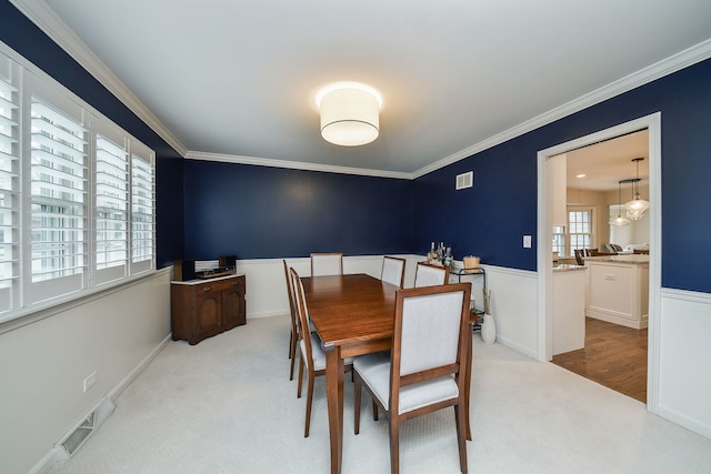 1007 Canonero Dr, Naperville, IL 60540 - carpeted dining area featuring crown molding, visible vents, and a wainscoted wall