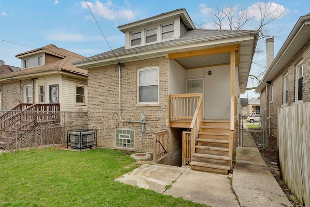 8742 S Justine St, Chicago, IL 60620 - back of house with a shingled roof, a lawn, fence, brick siding, and a gate