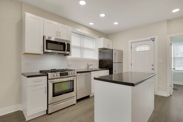 8742 S Justine St, Chicago, IL 60620 - kitchen with white cabinets, decorative backsplash, a sink, and appliances with stainless steel finishes
