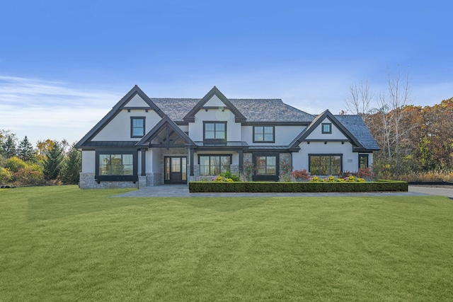 view of front facade with stucco siding, stone siding, a front lawn, a standing seam roof, and metal roof