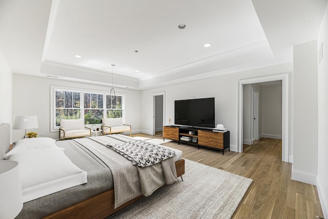 bedroom with recessed lighting, baseboards, a raised ceiling, and light wood-style floors