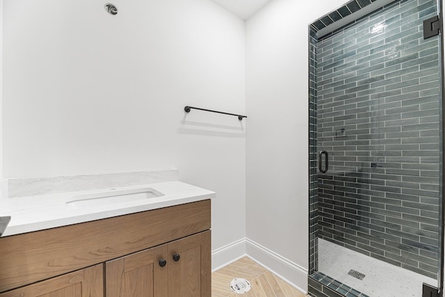 bathroom featuring a shower stall, vanity, and baseboards