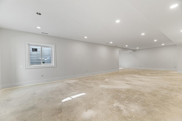 basement featuring baseboards, visible vents, and recessed lighting