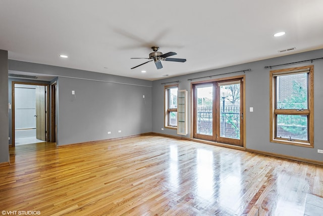 spare room featuring baseboards, visible vents, light wood-type flooring, and a ceiling fan
