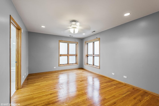 empty room with visible vents, light wood finished floors, and a ceiling fan