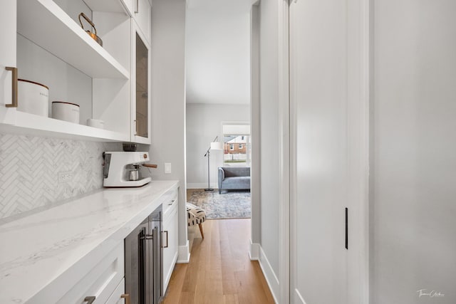hallway with baseboards, light wood-style flooring, and wine cooler