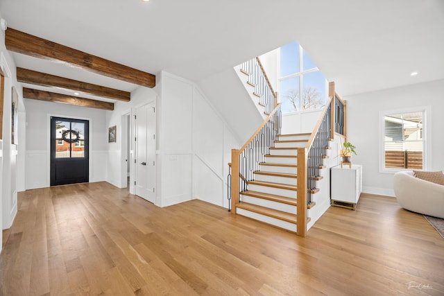 foyer featuring light wood-style floors, recessed lighting, beamed ceiling, and stairs