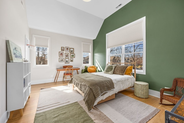 bedroom featuring visible vents, baseboards, lofted ceiling, and multiple windows