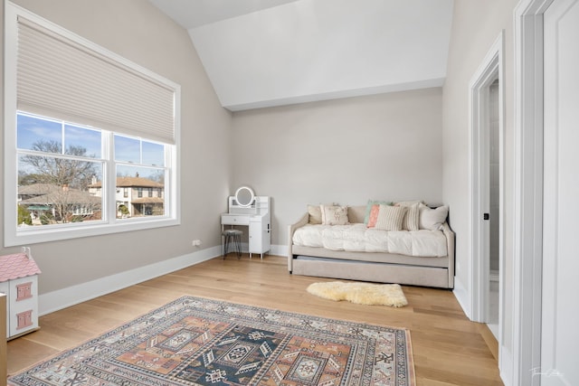 bedroom with light wood-style floors, baseboards, and lofted ceiling
