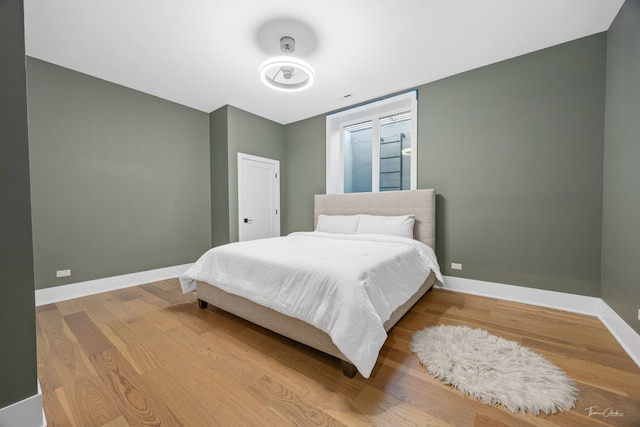 bedroom featuring baseboards and wood finished floors