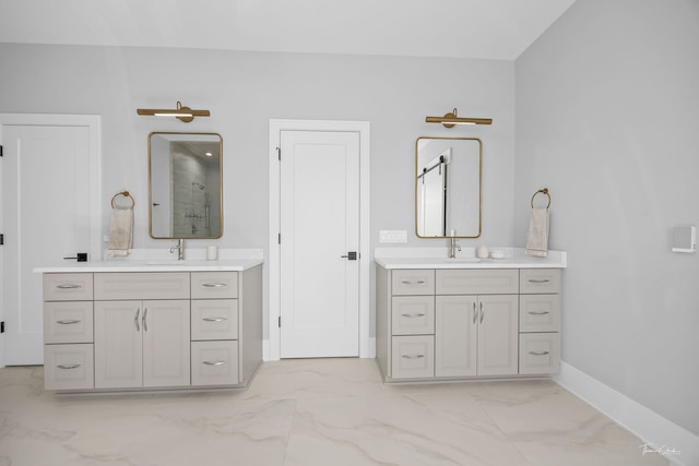bathroom featuring baseboards, walk in shower, a sink, and marble finish floor