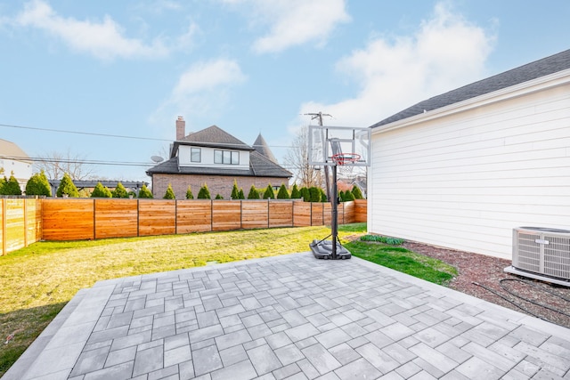 view of sport court with a fenced backyard and a yard