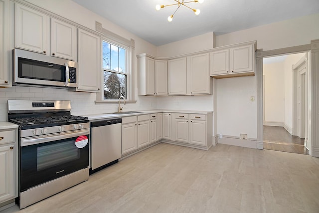 505 S Indiana Ave, Kankakee, IL 60901 - kitchen featuring light wood-style flooring, tasteful backsplash, light countertops, a sink, and stainless steel appliances