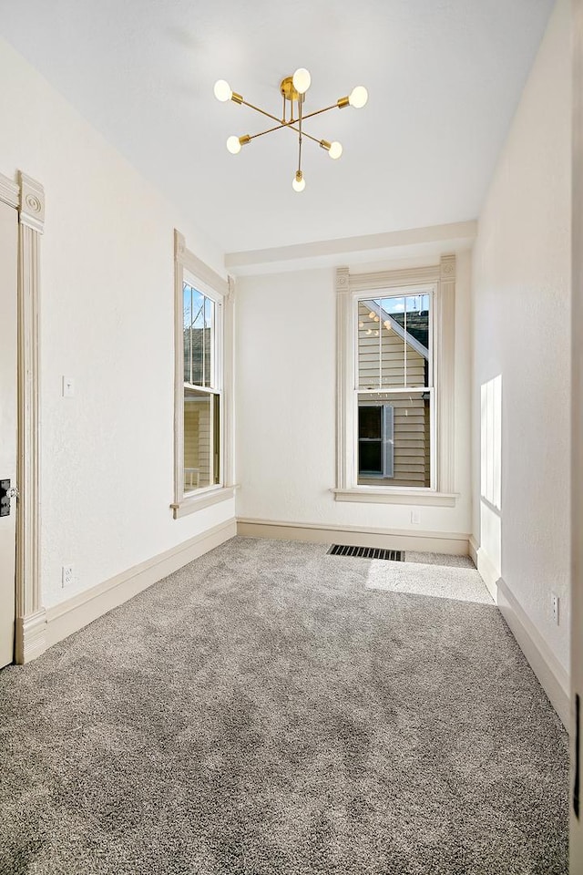505 S Indiana Ave, Kankakee, IL 60901 - spare room with a chandelier, baseboards, and carpet floors