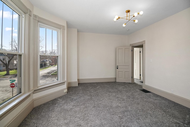 505 S Indiana Ave, Kankakee, IL 60901 - carpeted empty room with baseboards, a chandelier, and a healthy amount of sunlight