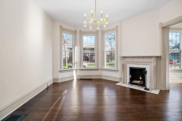 505 S Indiana Ave, Kankakee, IL 60901 - unfurnished living room featuring a brick fireplace, visible vents, an inviting chandelier, and wood finished floors