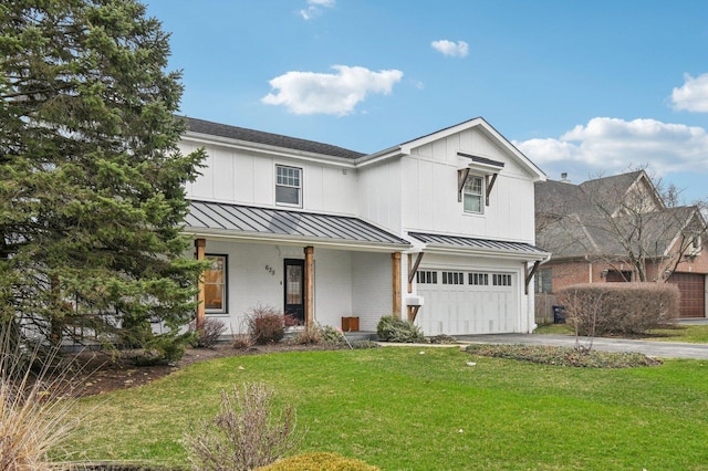 view of front of house with an attached garage, a front lawn, driveway, and a standing seam roof