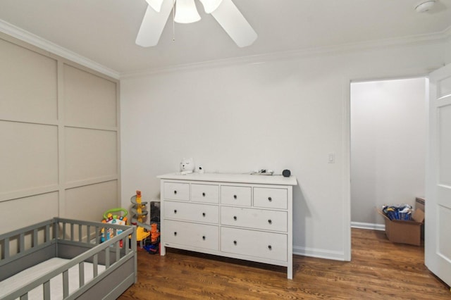 bedroom featuring crown molding, a crib, ceiling fan, and dark wood-style floors