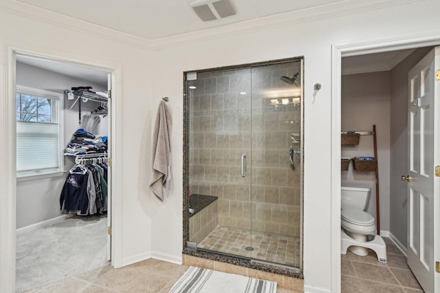 full bath featuring visible vents, ornamental molding, toilet, a walk in closet, and a shower stall