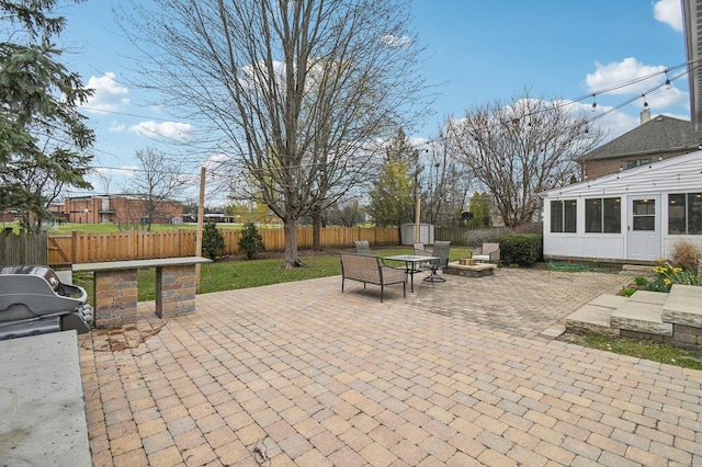 view of patio featuring an outdoor fire pit, area for grilling, a shed, a fenced backyard, and an outdoor structure