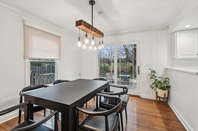 dining space featuring baseboards, ornamental molding, and wood finished floors