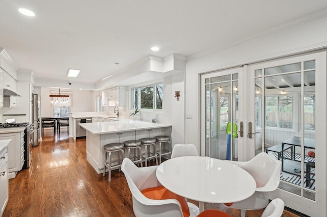 dining room with dark wood-style flooring, recessed lighting, ornamental molding, and french doors