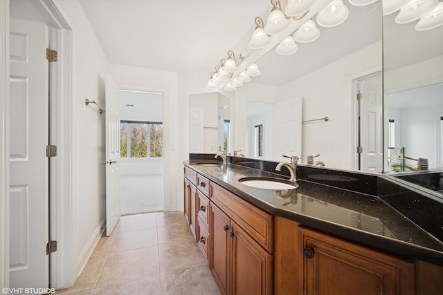 full bath featuring a sink, tile patterned floors, double vanity, and baseboards