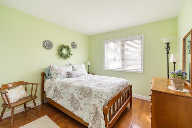 bedroom with wood finished floors and baseboards