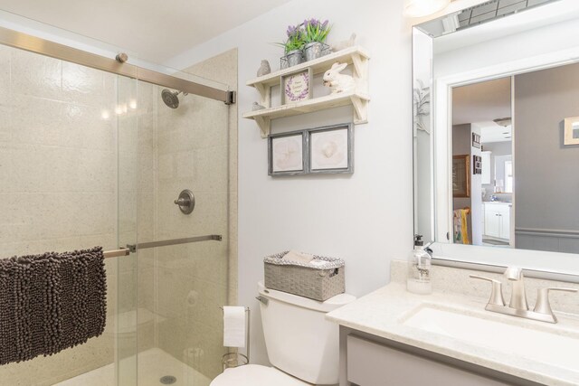 bathroom featuring a stall shower, toilet, and vanity