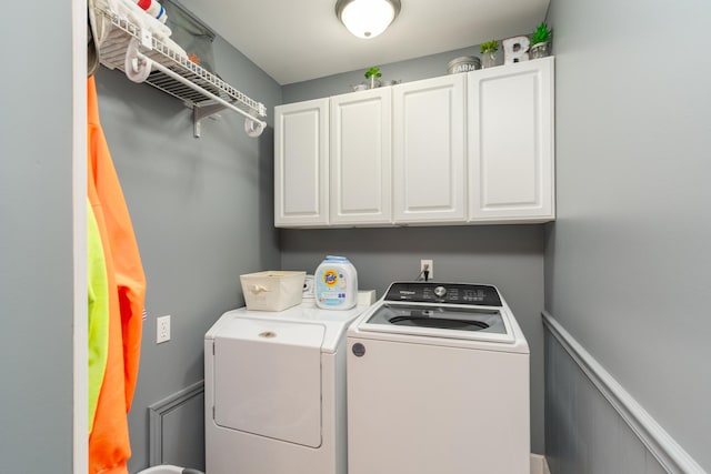 washroom with washing machine and dryer and cabinet space