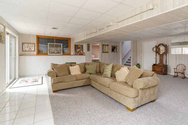 130333020 E St, Spring Valley, IL 61362 - carpeted living room featuring stairs, a drop ceiling, tile patterned flooring, and wood walls