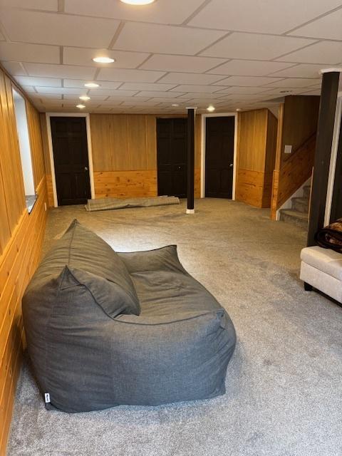 678 Meridian Way, Antioch, IL 60002 - carpeted living area featuring wooden walls, stairway, and a paneled ceiling