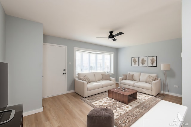 living area featuring light wood-style flooring, baseboards, and a ceiling fan