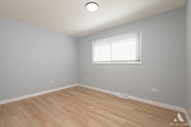 spare room with light wood-style flooring, baseboards, and visible vents