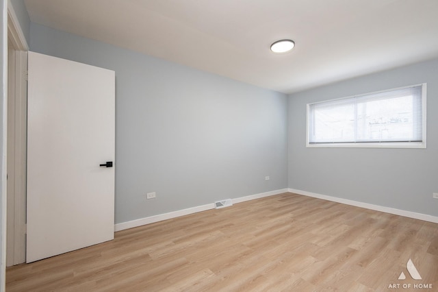 spare room with visible vents, baseboards, and light wood-style floors