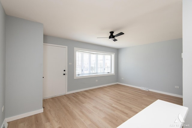 interior space with light wood finished floors, visible vents, baseboards, and ceiling fan
