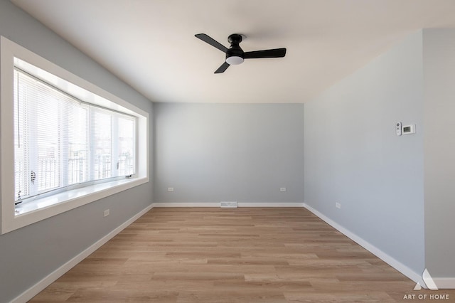 unfurnished room featuring light wood-type flooring, ceiling fan, baseboards, and visible vents