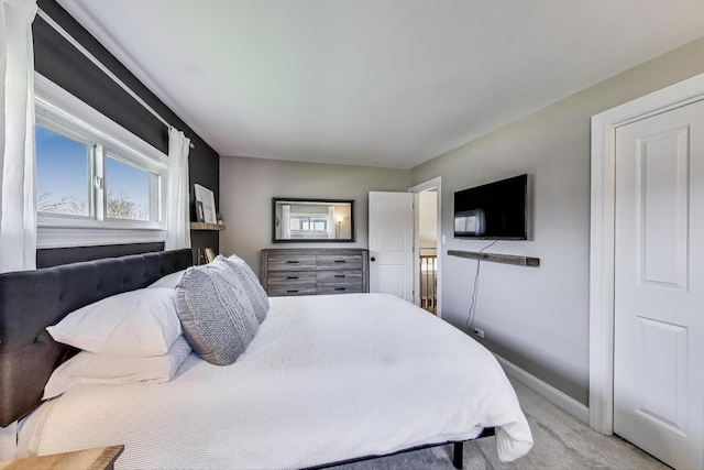 bedroom with light carpet and baseboards