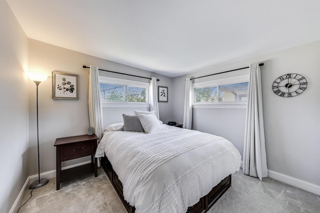 bedroom with light carpet and baseboards